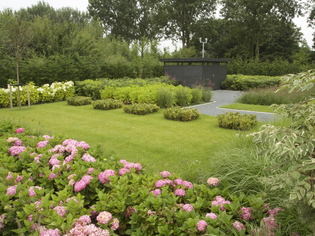 Moderne tuin met verhoogde vijver en golfgreen